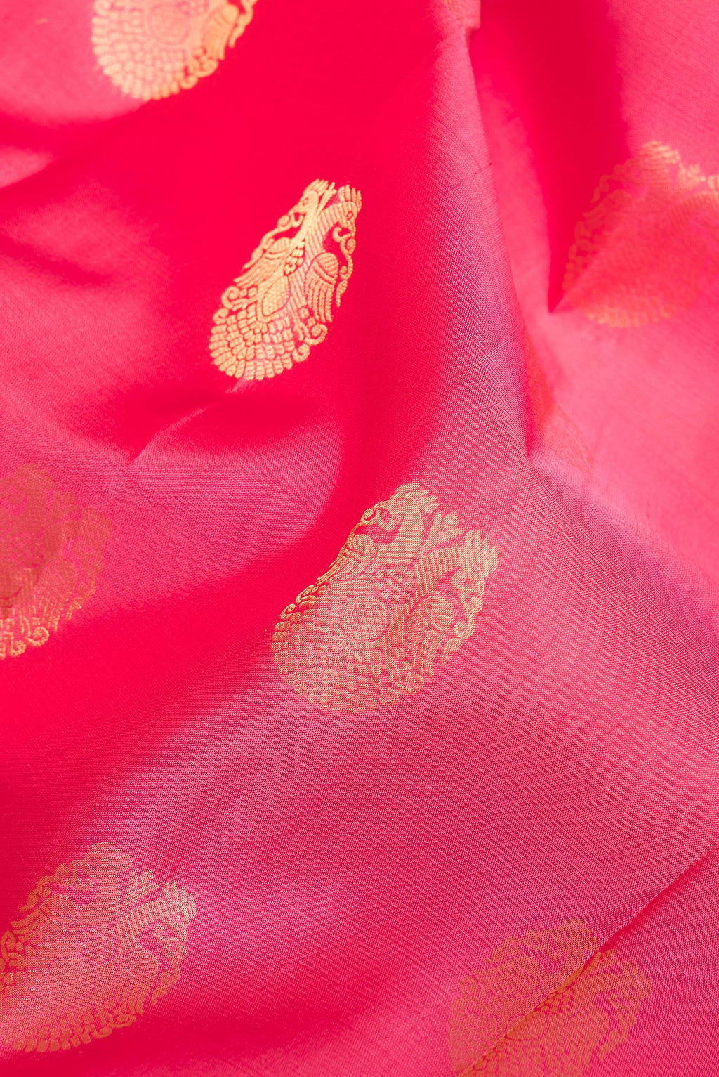Close up of Pure Silk Coral Kanjivaram Saree with Zari Butta on the body and Zari Border.  displaying folds