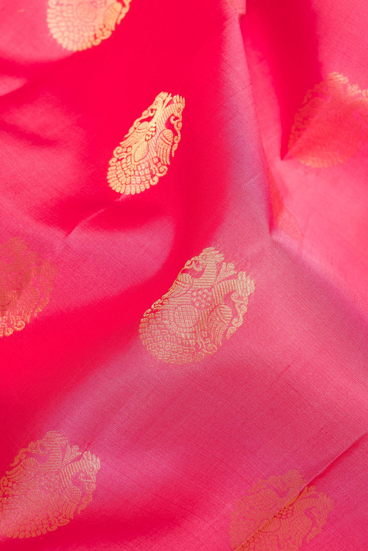 Close up of Pure Silk Coral Kanjivaram Saree with Zari Butta on the body and Zari Border.  displaying folds