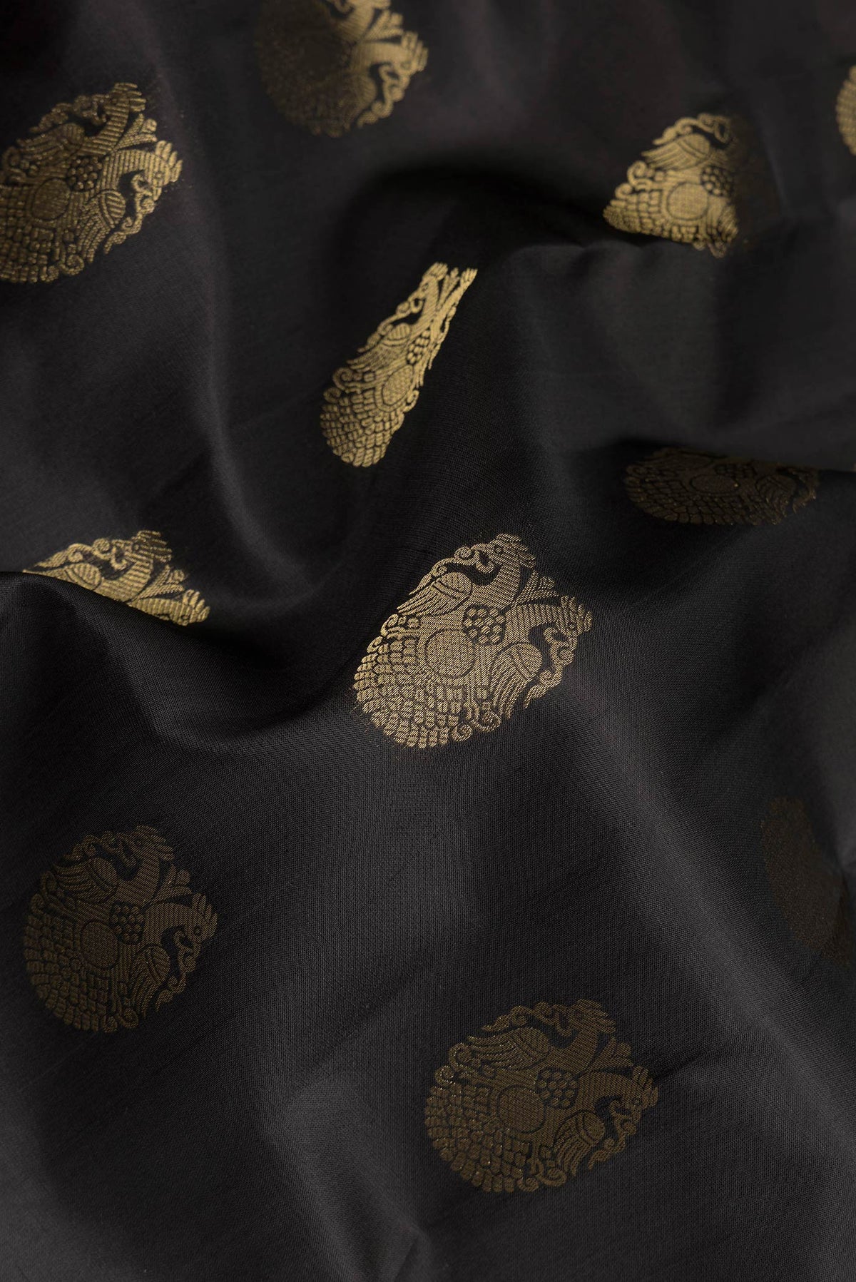 Close up of Pure Silk Black Kanjivaram Saree with Zari Butta on the body and Zari Border.  displaying folds