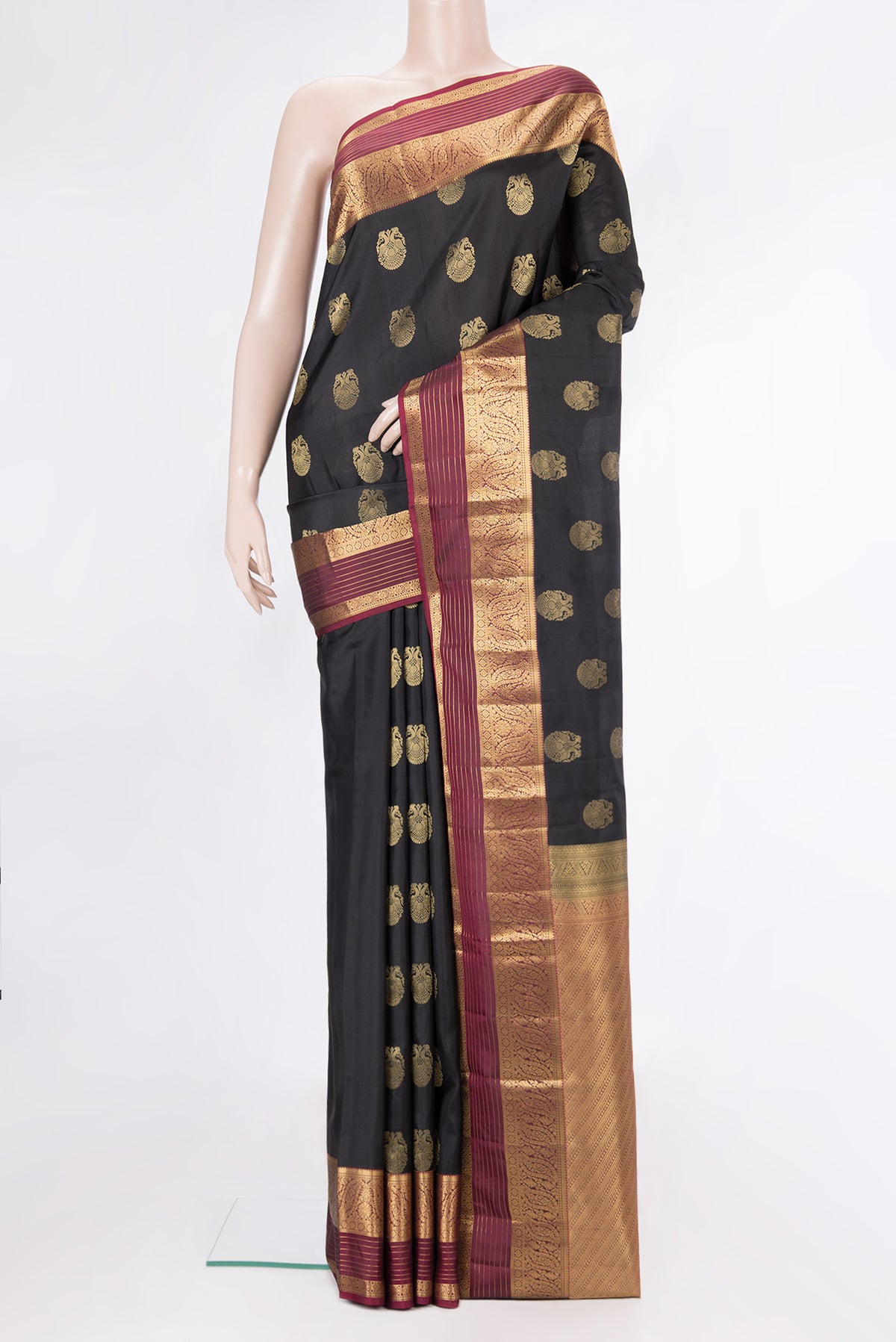 Pure Silk Black Kanjivaram Saree with Zari Butta on the body and Zari Border.  displayed on a mannequin