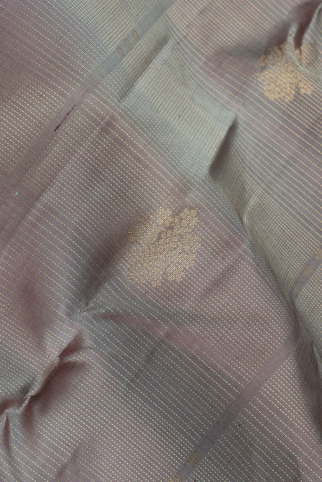 Close up of Pure Silk Grey Kanchipuram Saree with Zari Butta on the body and Zari Border.  displaying folds