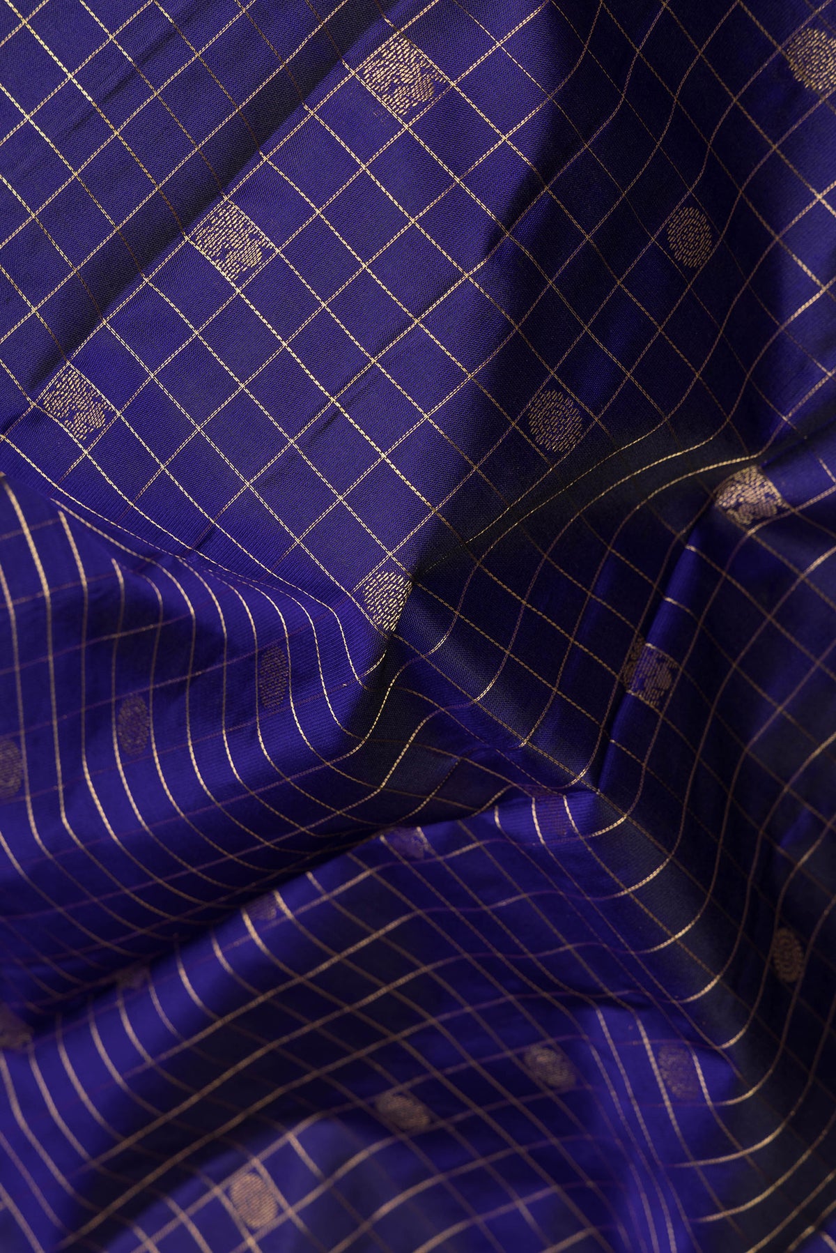 Close up of Pure Silk Dark Blue Kanchipuram Saree with Checked design on the body and Zari Border.  displaying folds