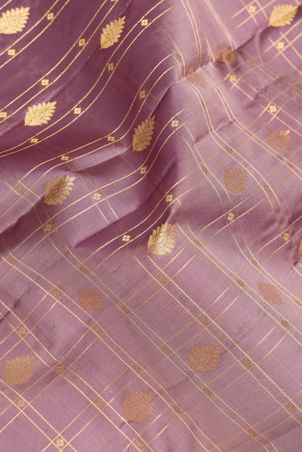 Close up of Pure Silk Rose Gold Kanchipuram Saree with Checked design on the body and Zari Border.  displaying folds