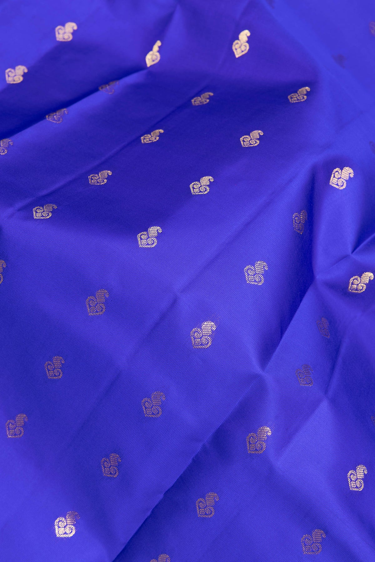 Close up of Pure Silk Royal Blue Kanchipuram Saree with Zari Butta on the body and Zari Border.  displaying folds