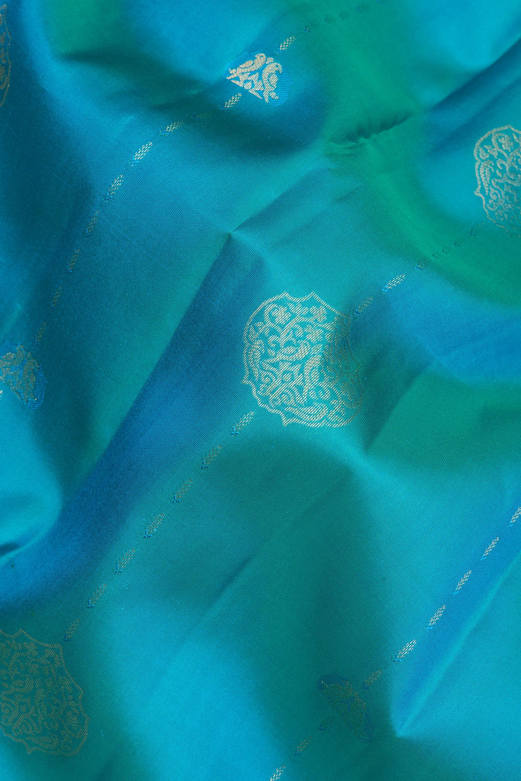 Close up of Pure Silk Peacock Blue Kanchipuram Saree with Zari Butta on the body and Zari Border.  displaying folds