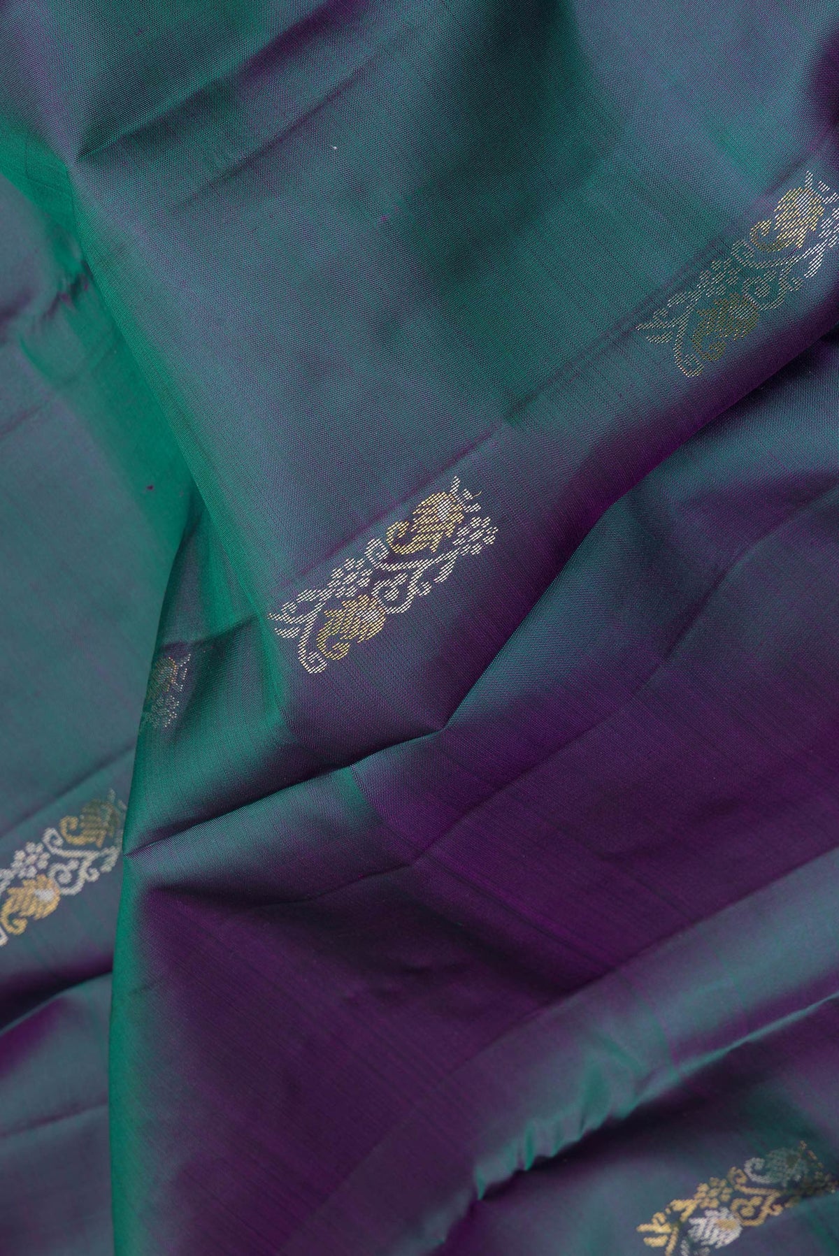 Close up of Pure Silk Peacock Blue Dual Tone Kanchipuram Saree with Zari Butta on the body and Plain Border.  displaying folds