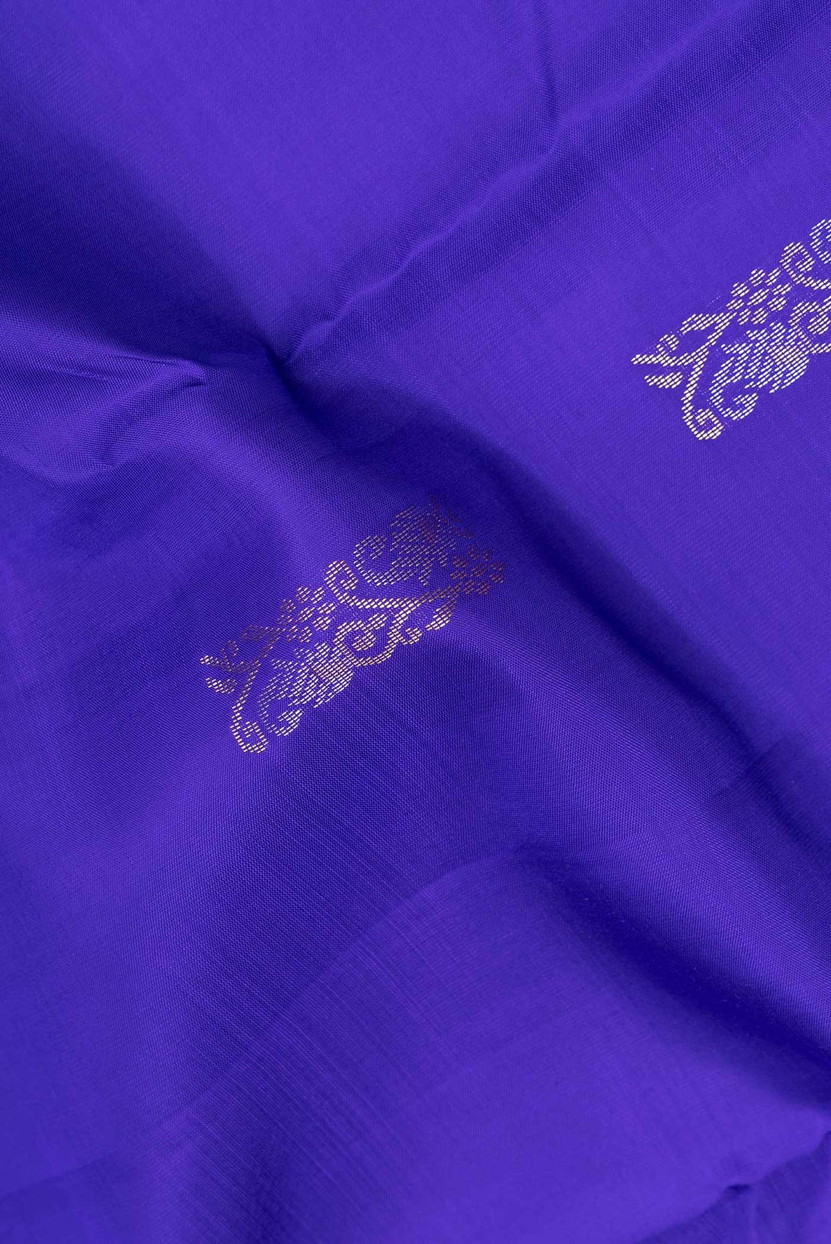 Close up of Pure Silk Royal Blue Kanchipuram Saree with Zari Butta on the body and Zari Border.  displaying folds