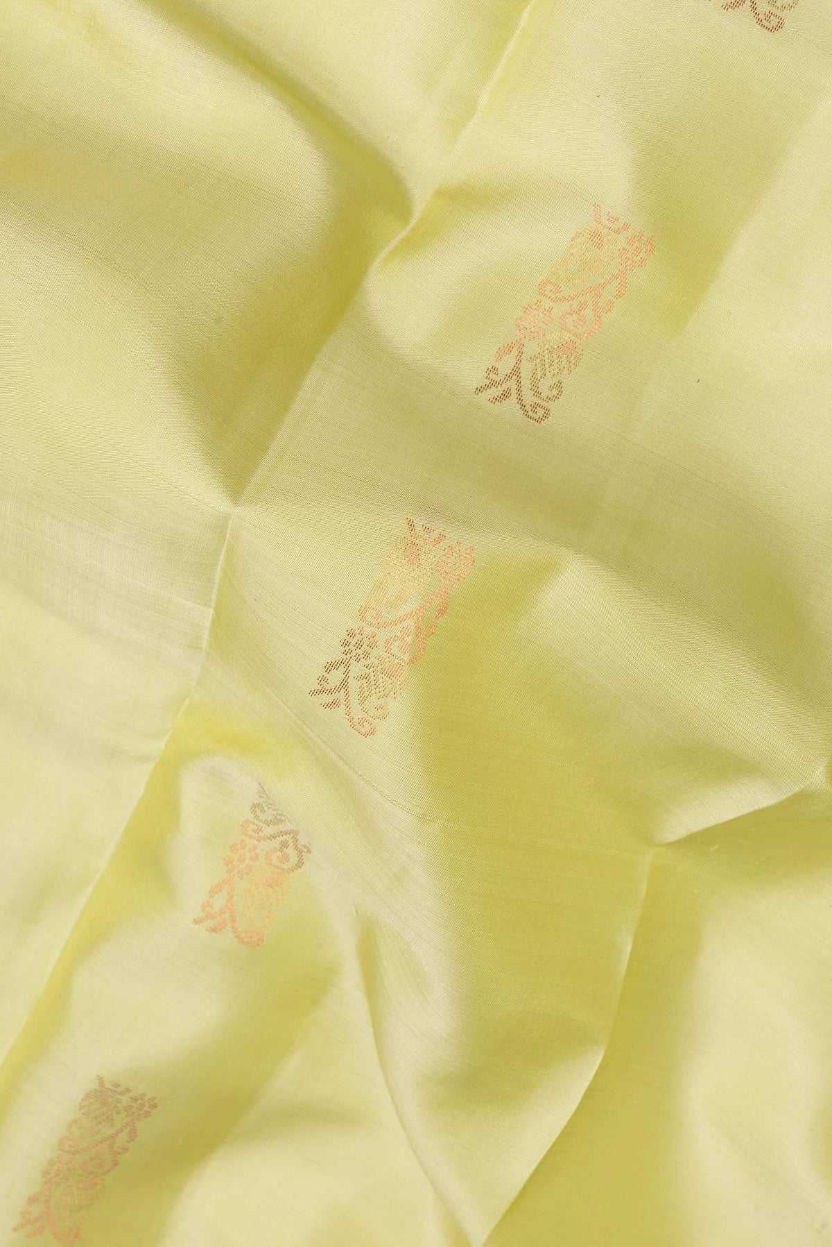Close up of Pure Silk Lemon Yellow Kanchipuram Saree with Zari Butta on the body and Plain Border.  displaying folds