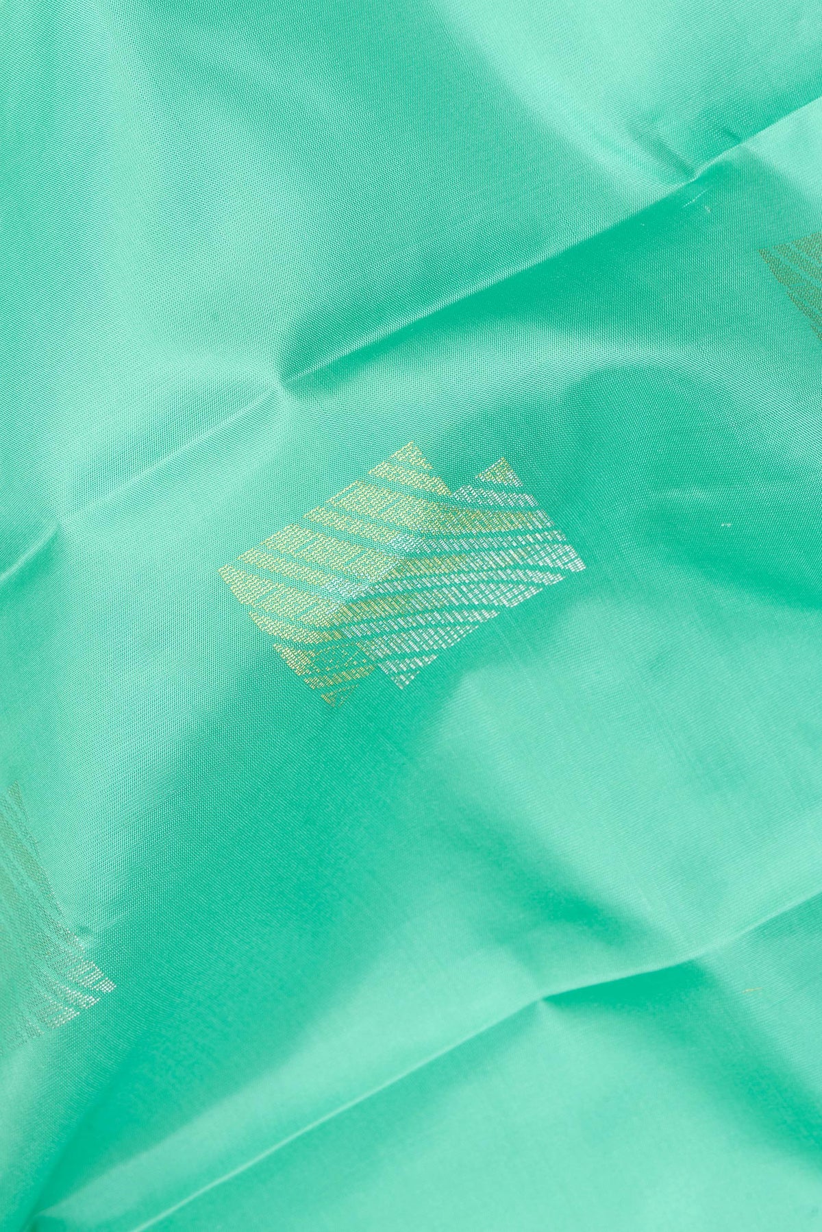 Close up of Pure Silk Sea Green Dual Tone Kanchipuram Saree with Zari Butta on the body and Plain Border.  displaying folds