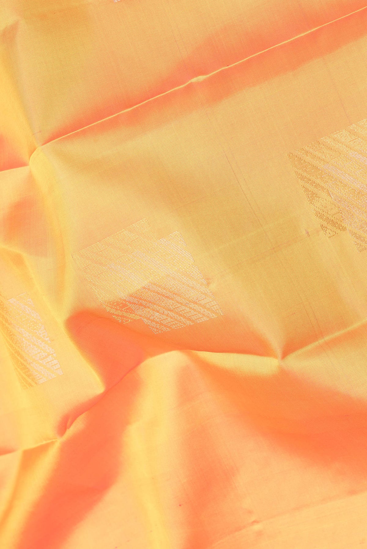 Close up of Pure Silk Mustard Kanchipuram Saree with Zari Butta on the body and Plain Border.  displaying folds