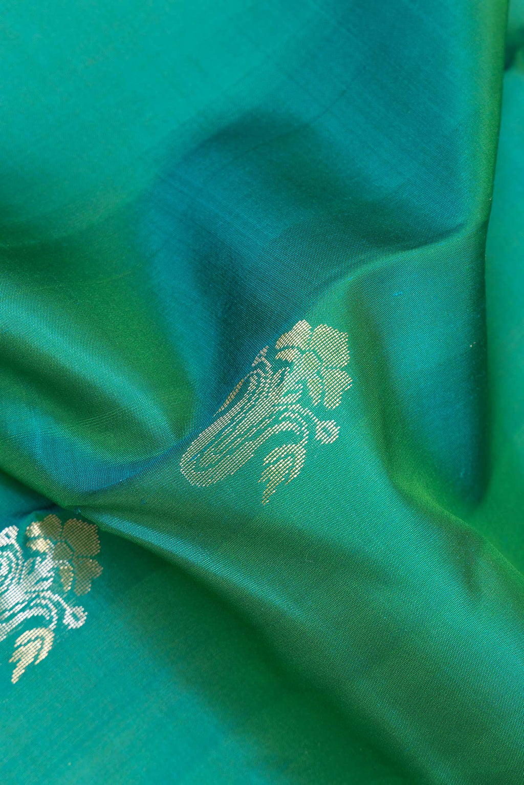 Close up of Pure Silk Green Kanchipuram Saree with Zari Butta on the body and Zari Border.  displaying folds