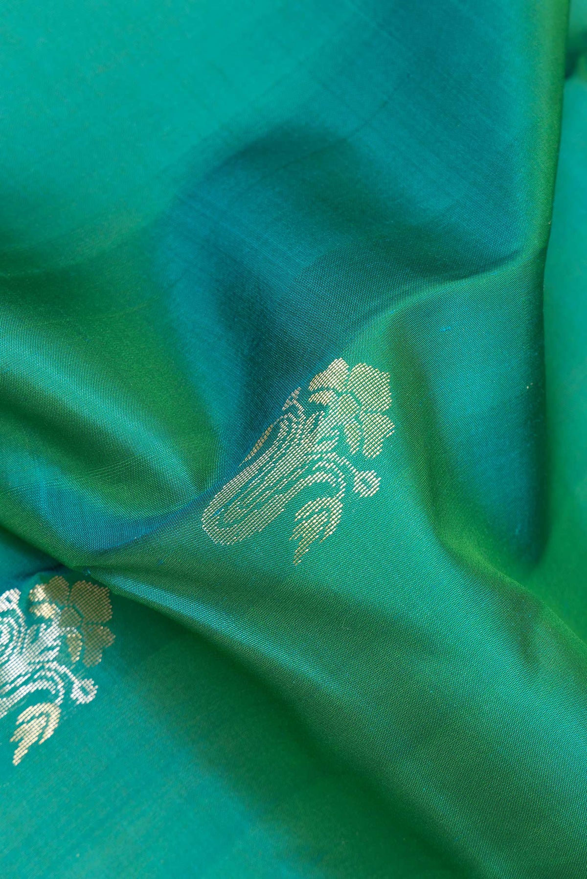Close up of Pure Silk Green Kanchipuram Saree with Zari Butta on the body and Zari Border.  displaying folds