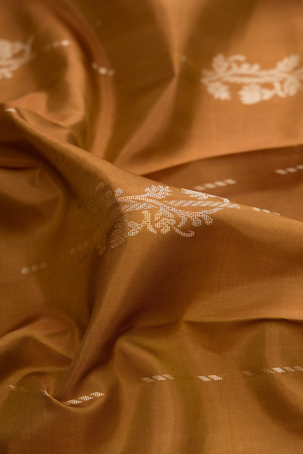 Close up of Pure Silk Brown Kanjivaram Saree with Thread Butta on the body and Thread Border.  displaying folds
