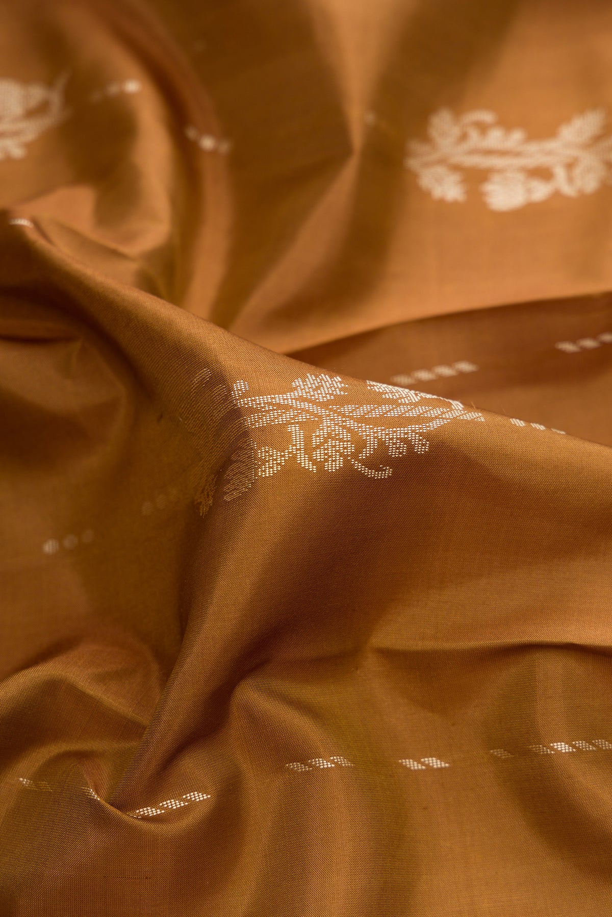 Close up of Pure Silk Brown Kanjivaram Saree with Thread Butta on the body and Thread Border.  displaying folds