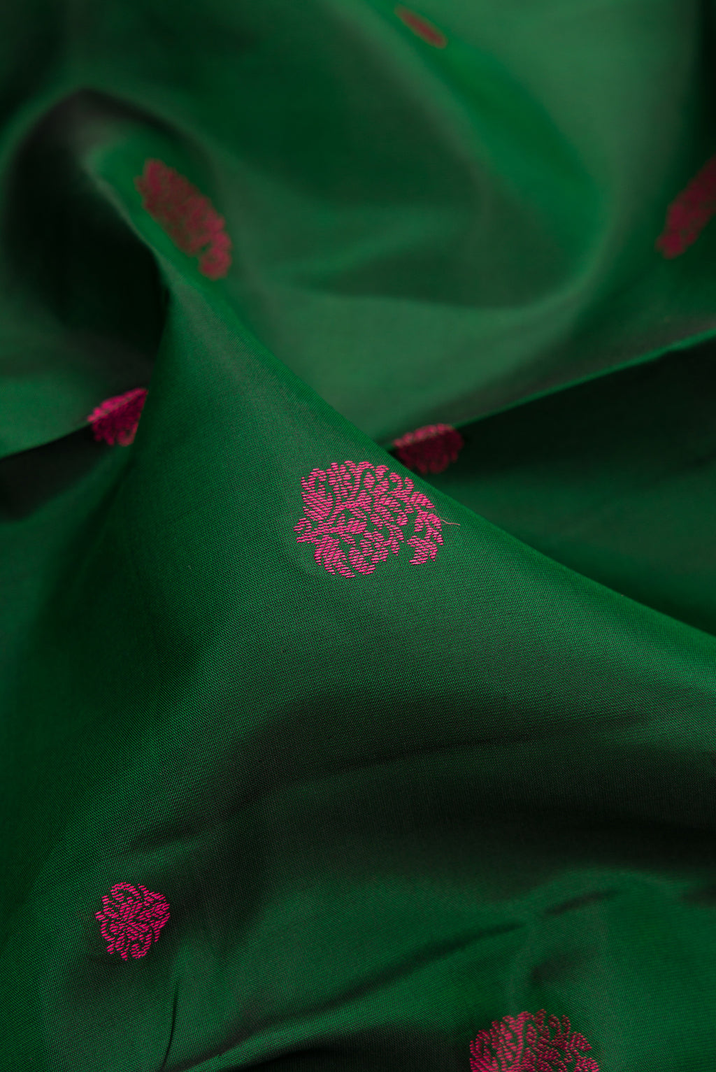 Close up of Pure Silk Bottle Green Dual Tone Kanchipuram Saree with Thread Butta on the body and Thread Border.  displaying folds