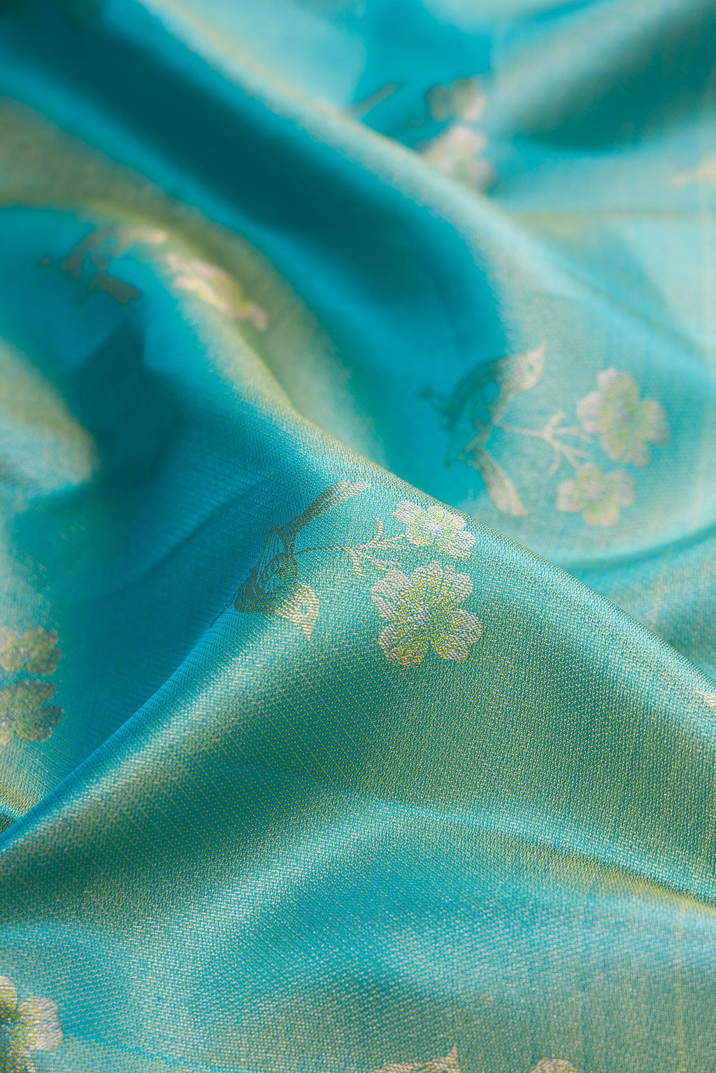 Close up of Pure Silk Sky Blue Kanchipuram Tissue Saree with Zari Butta on the body and Fancy Border.  displaying folds