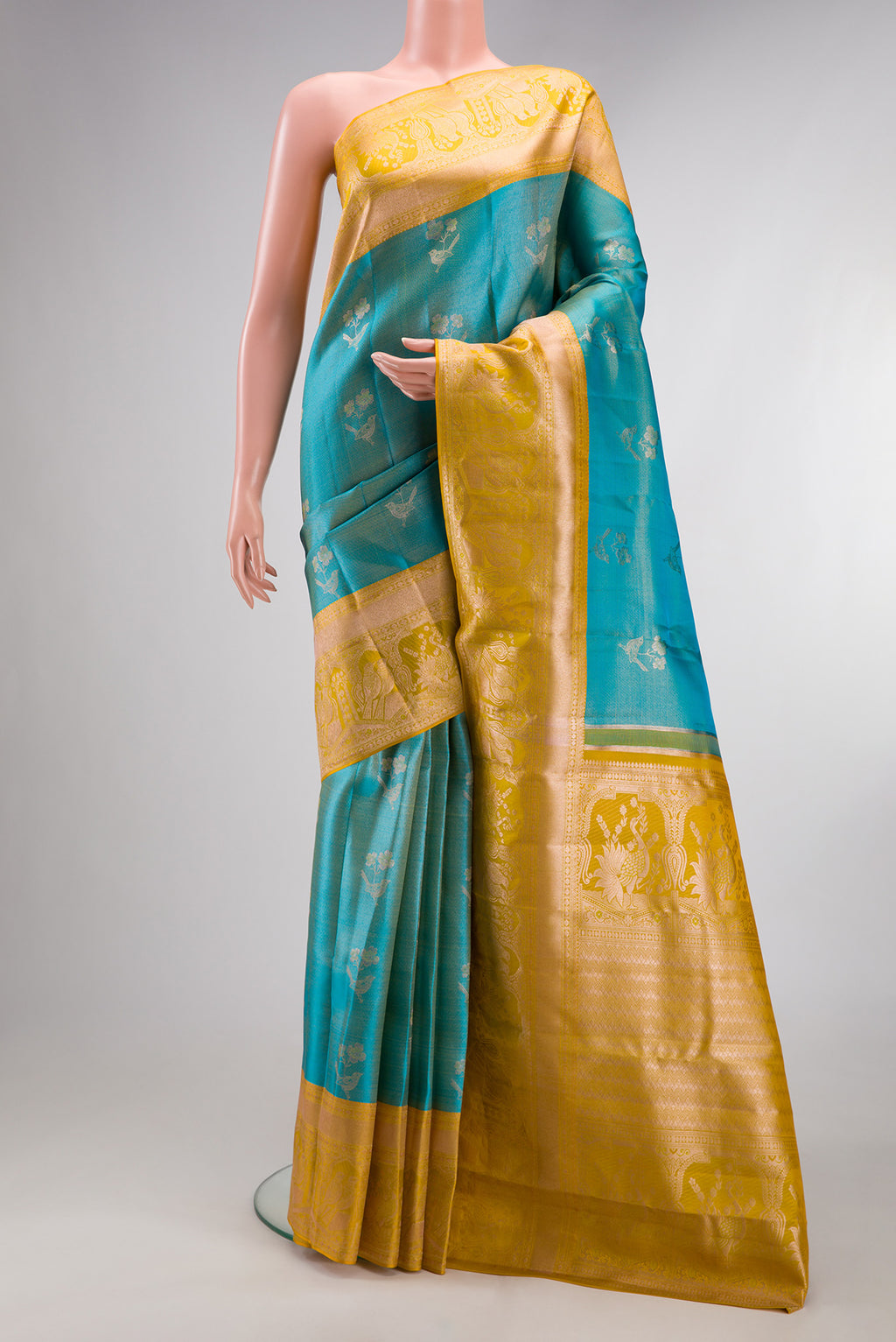 Pure Silk Sky Blue Kanchipuram Tissue Saree with Zari Butta on the body and Fancy Border.  displayed on a mannequin