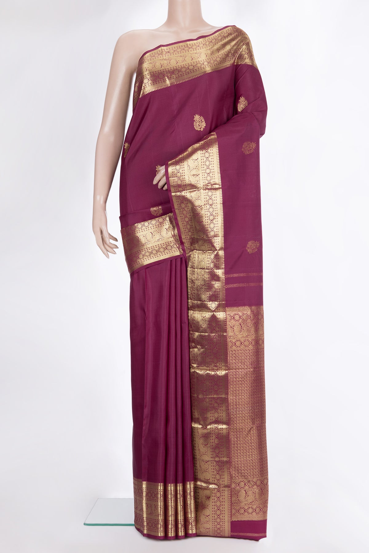 Pure Silk Maroon Kanjivaram Saree with Zari Butta on the body and Zari Border.  displayed on a mannequin