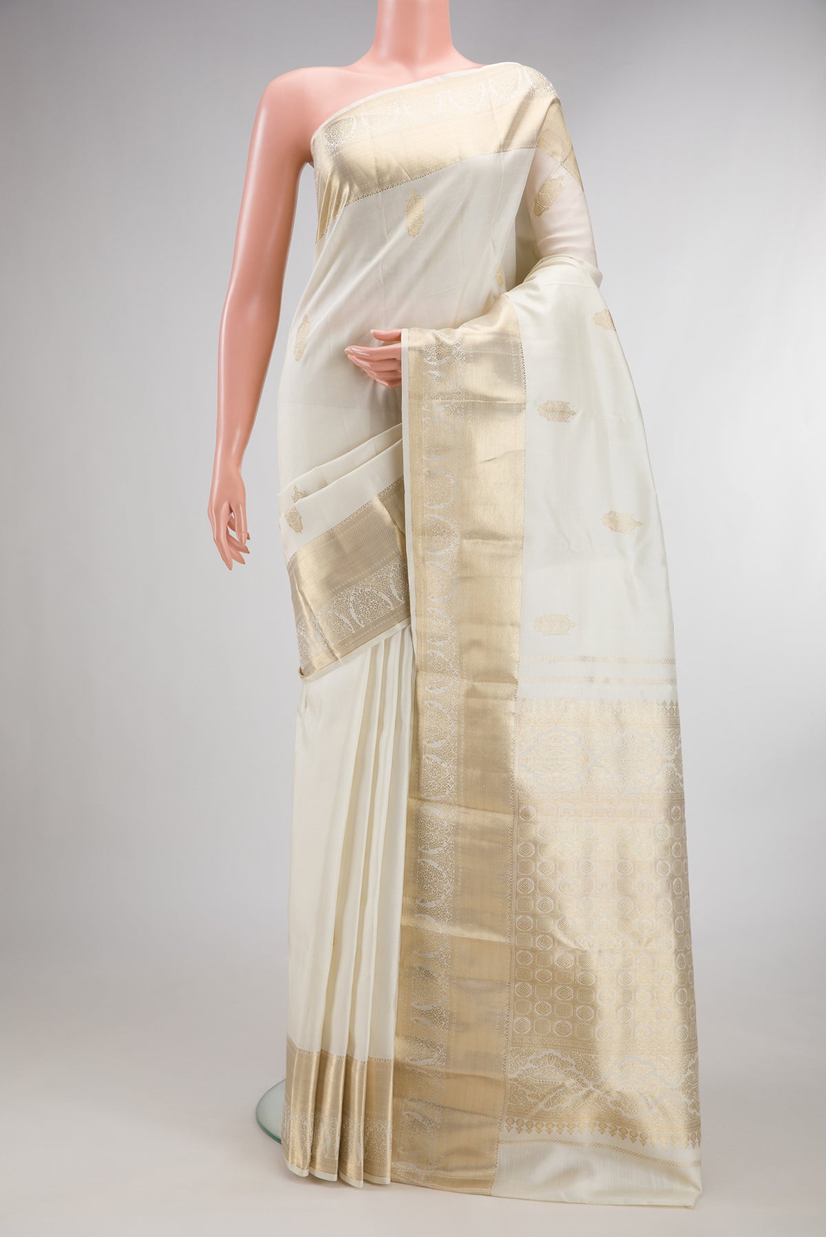 Pure Silk Off White Kanjivaram Saree with Zari Butta on the body and Zari Border.  displayed on a mannequin