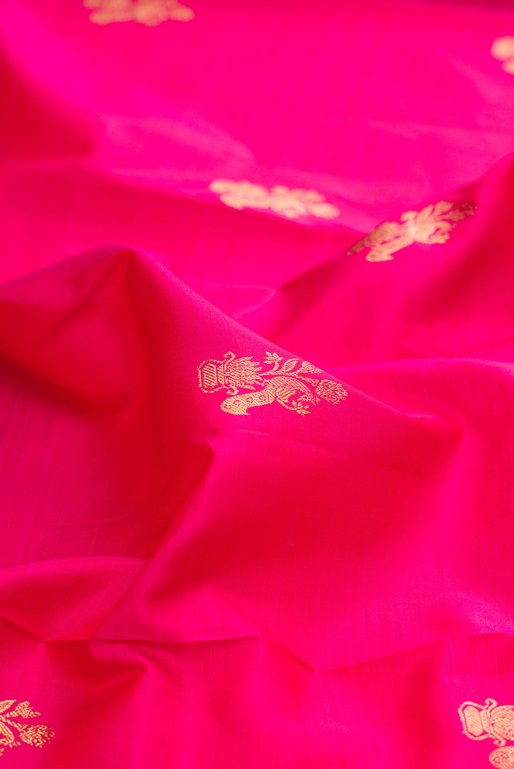 Close up of Pure Silk Pink Kanjivaram Saree with Zari Butta on the body and Zari Border.  displaying folds