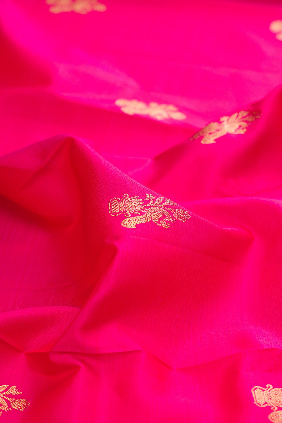 Close up of Pure Silk Pink Kanjivaram Saree with Zari Butta on the body and Zari Border.  displaying folds
