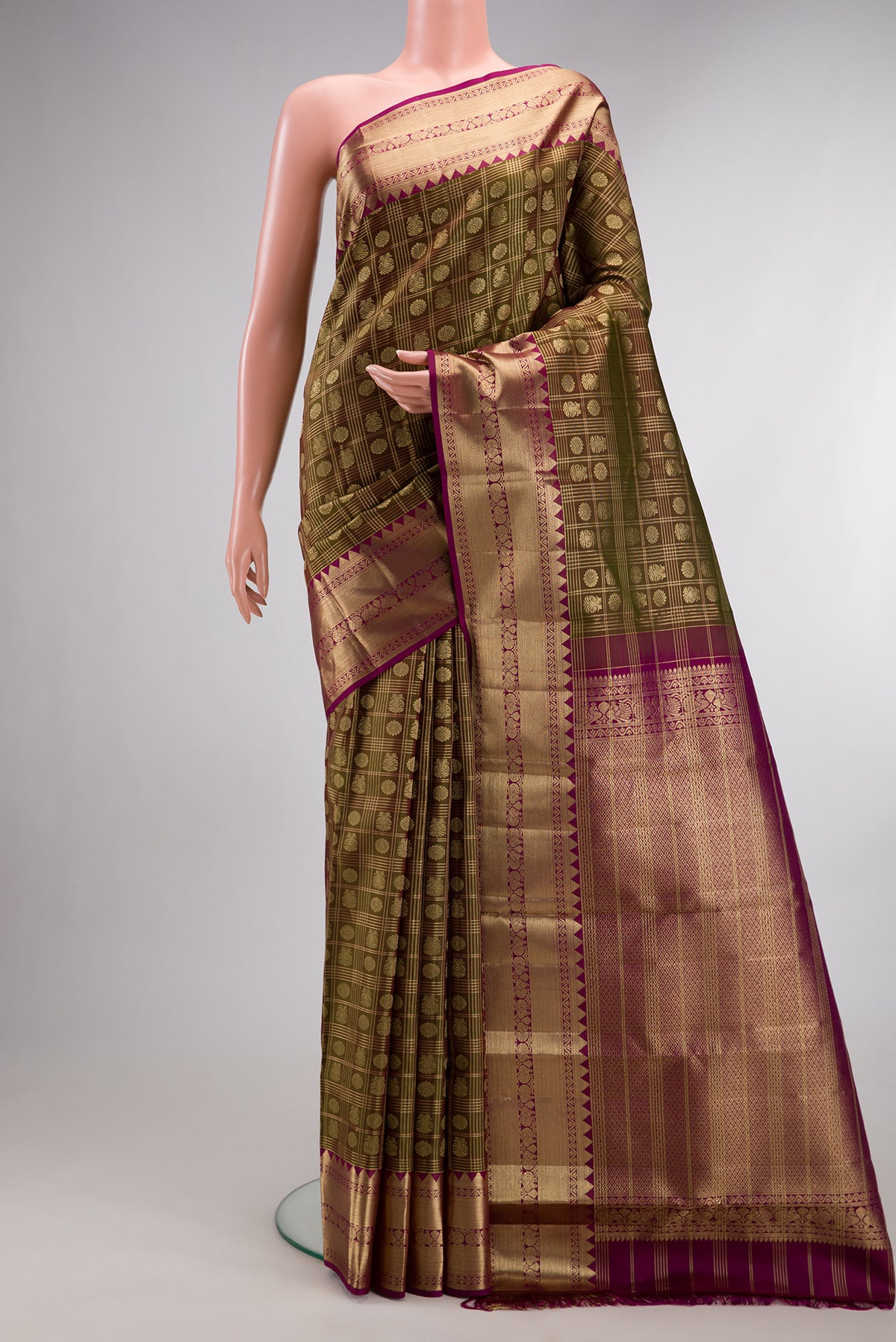 Pure Silk Mehandi Green Kanchipuram Saree with Zari Brocade on the body and Fancy Border.  displayed on a mannequin