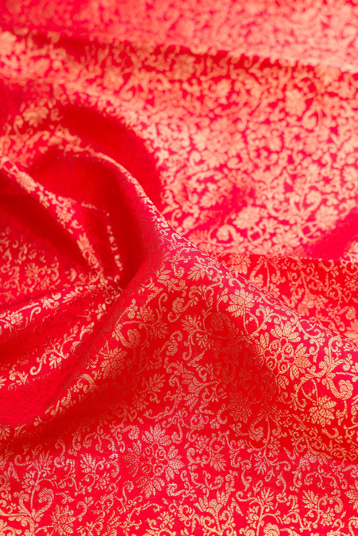 Close up of Pure Silk Red Dual Tone Kanchipuram Saree with Zari Brocade on the body and Zari Border.  displaying folds
