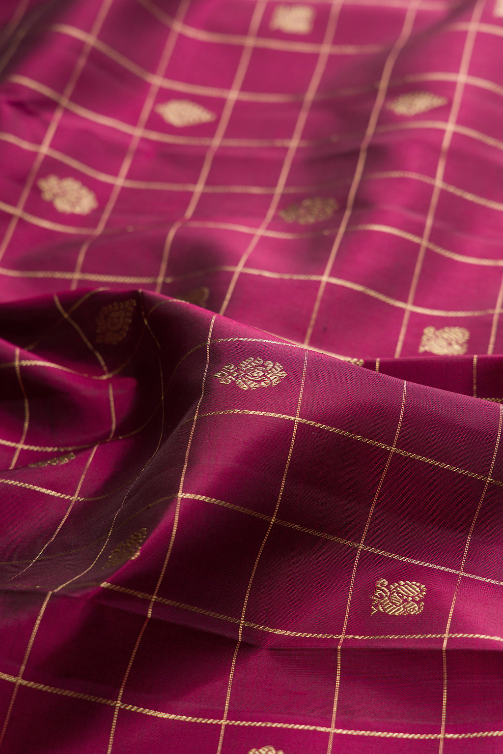 Close up of Pure Silk Maroon Kanchipuram Saree with Checked design on the body and Zari Border.  displaying folds