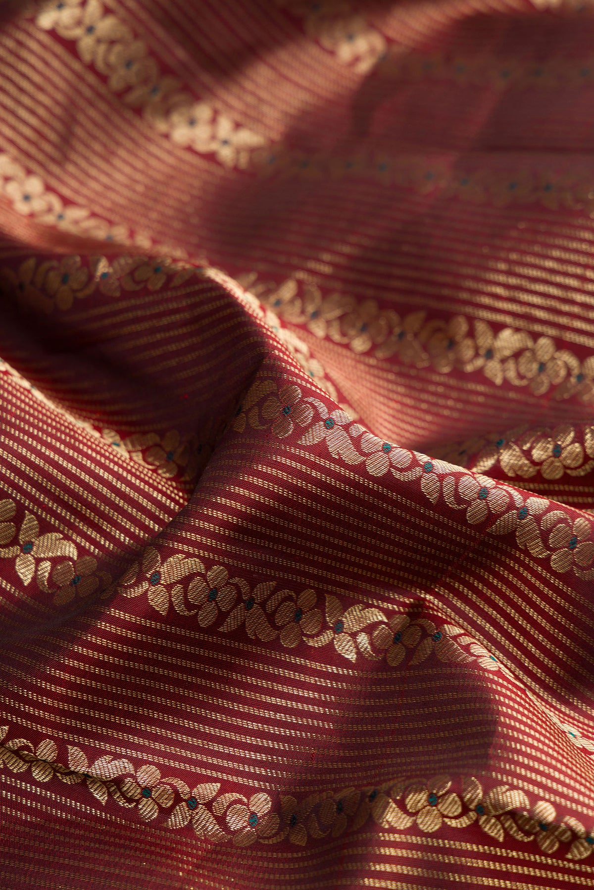 Close up of Pure Silk Maroon Dual Tone Kanchipuram Saree with Zari Brocade on the body and Fancy Border.  displaying folds