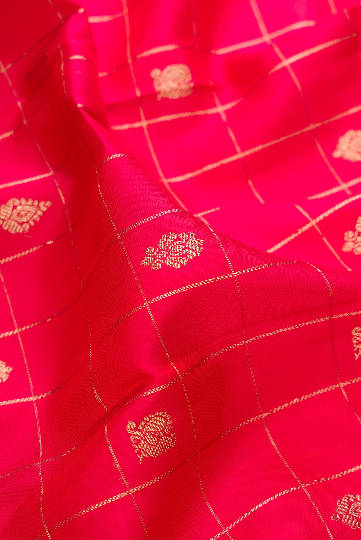 Close up of Pure Silk Dark Pink Dual Tone Kanchipuram Saree with Checked design on the body and Zari Border.  displaying folds