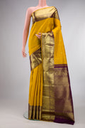 Pure Silk Mustard Kanjivaram Saree with Zari Butta on the body and Zari Border.  displayed on a mannequin
