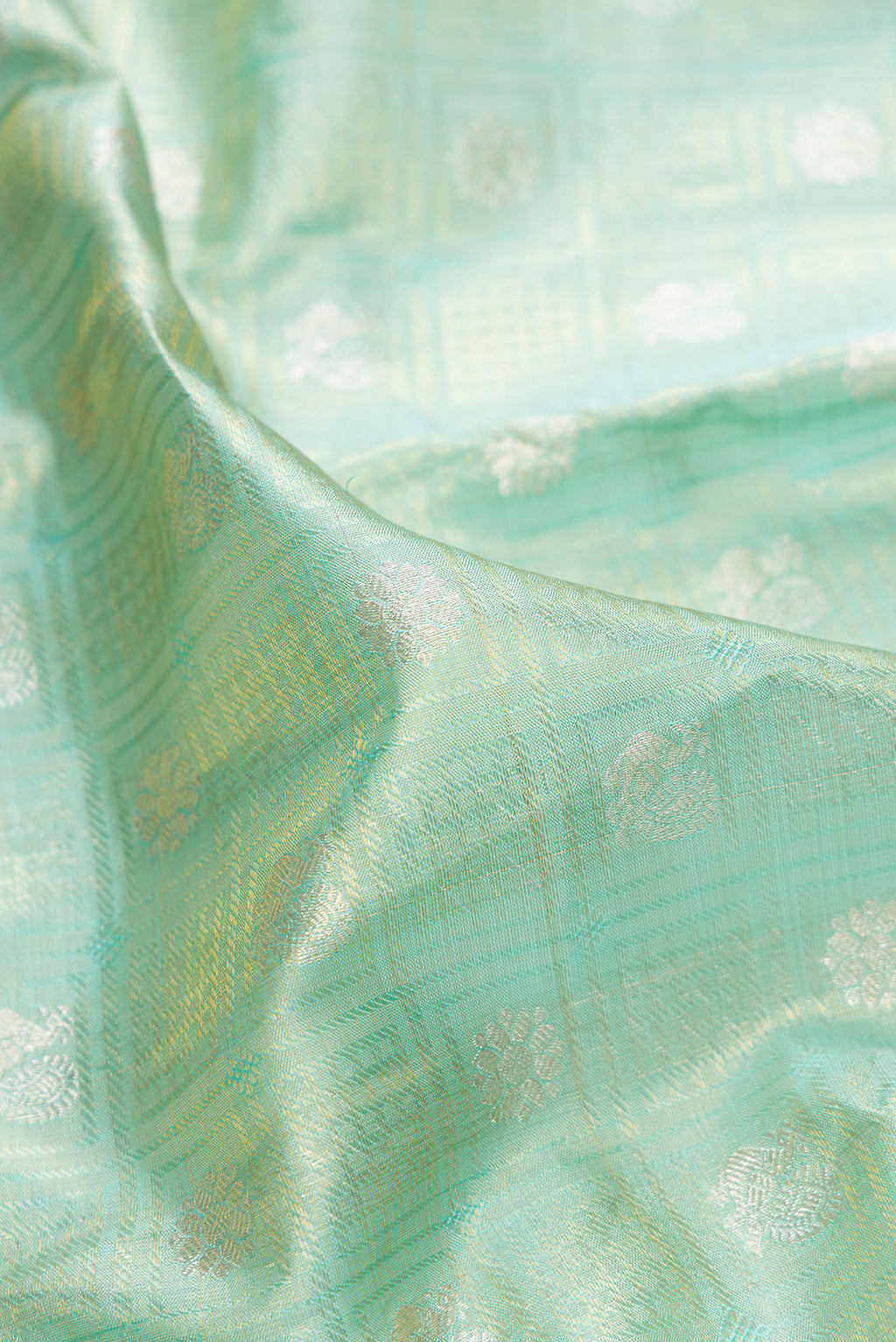 Close up of Sea Green Dual Tone Kanchipuram Tissue Saree with Zari Brocade on the body and Fancy Border.  displaying folds