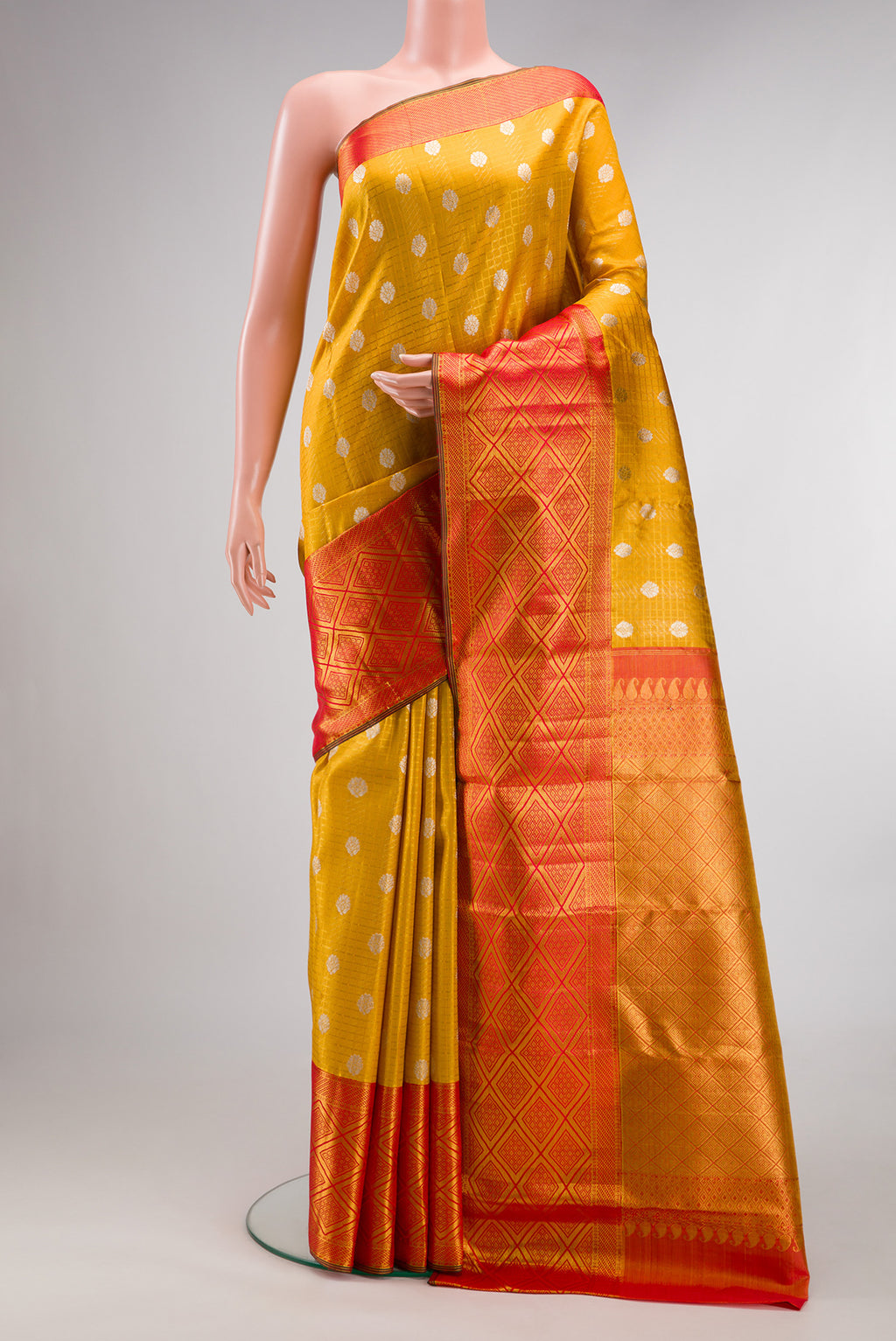 Mustard Kanchipuram Tissue Saree with Zari Brocade on the body and Fancy Border.  displayed on a mannequin