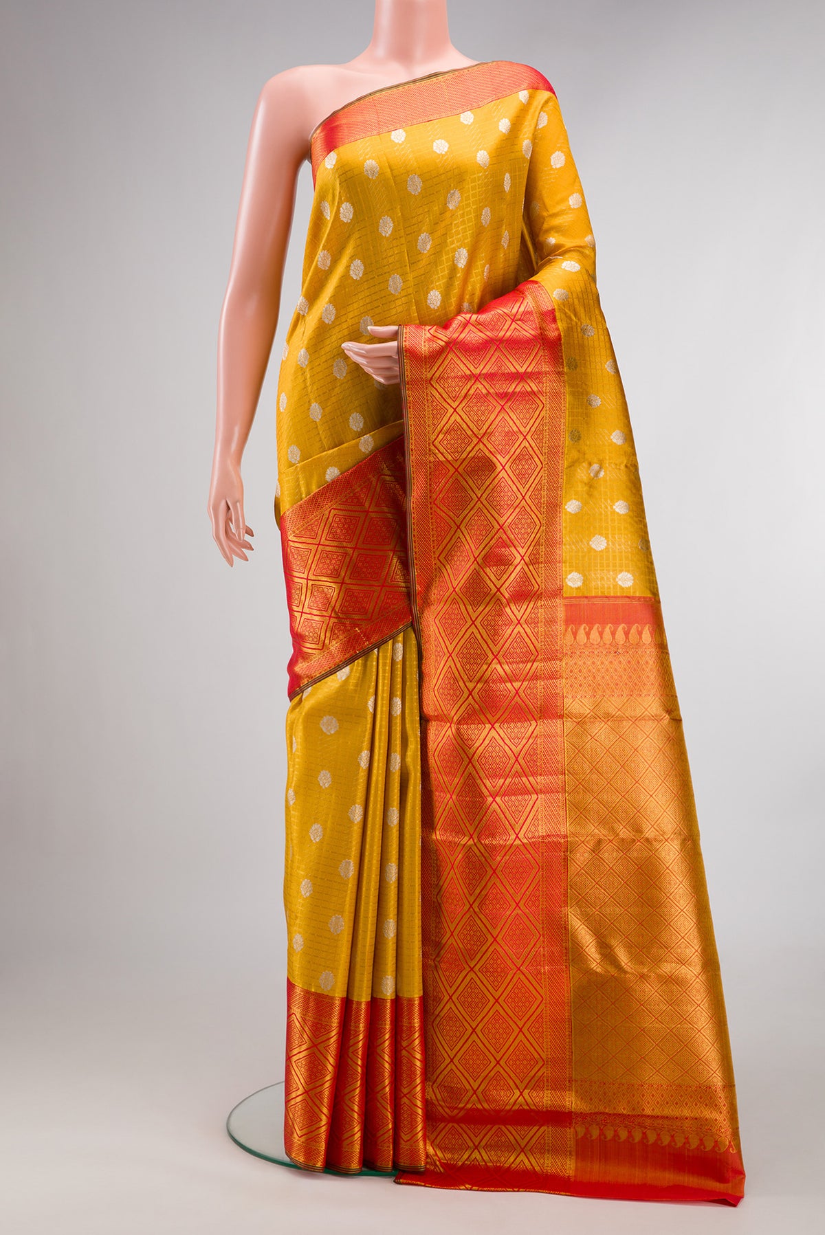 Mustard Kanchipuram Tissue Saree with Zari Brocade on the body and Fancy Border.  displayed on a mannequin