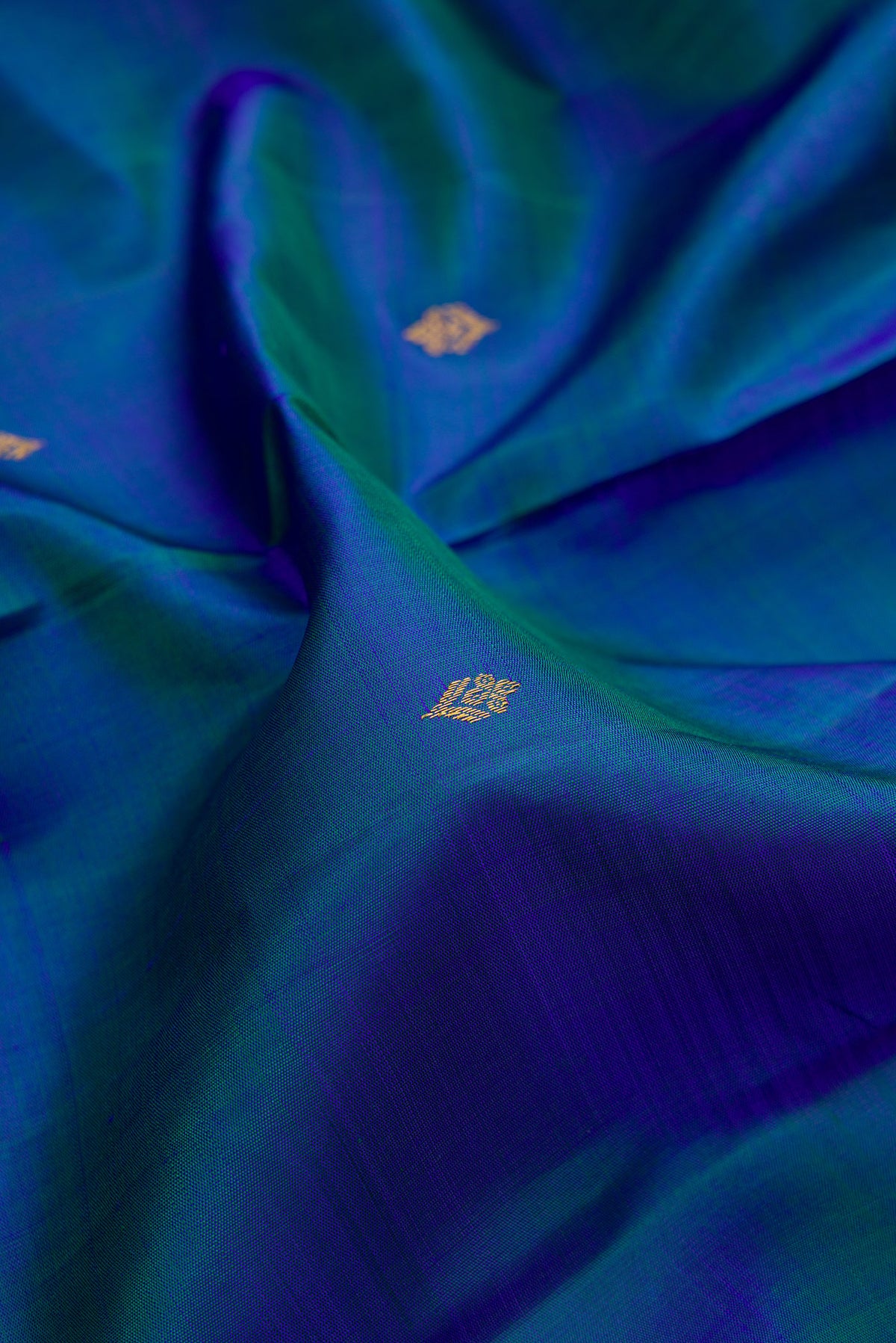 Close up of Pure Silk Peacock Blue Dual Tone Kanjivaram Saree with Zari Butta on the body and Zari Border.  displaying folds