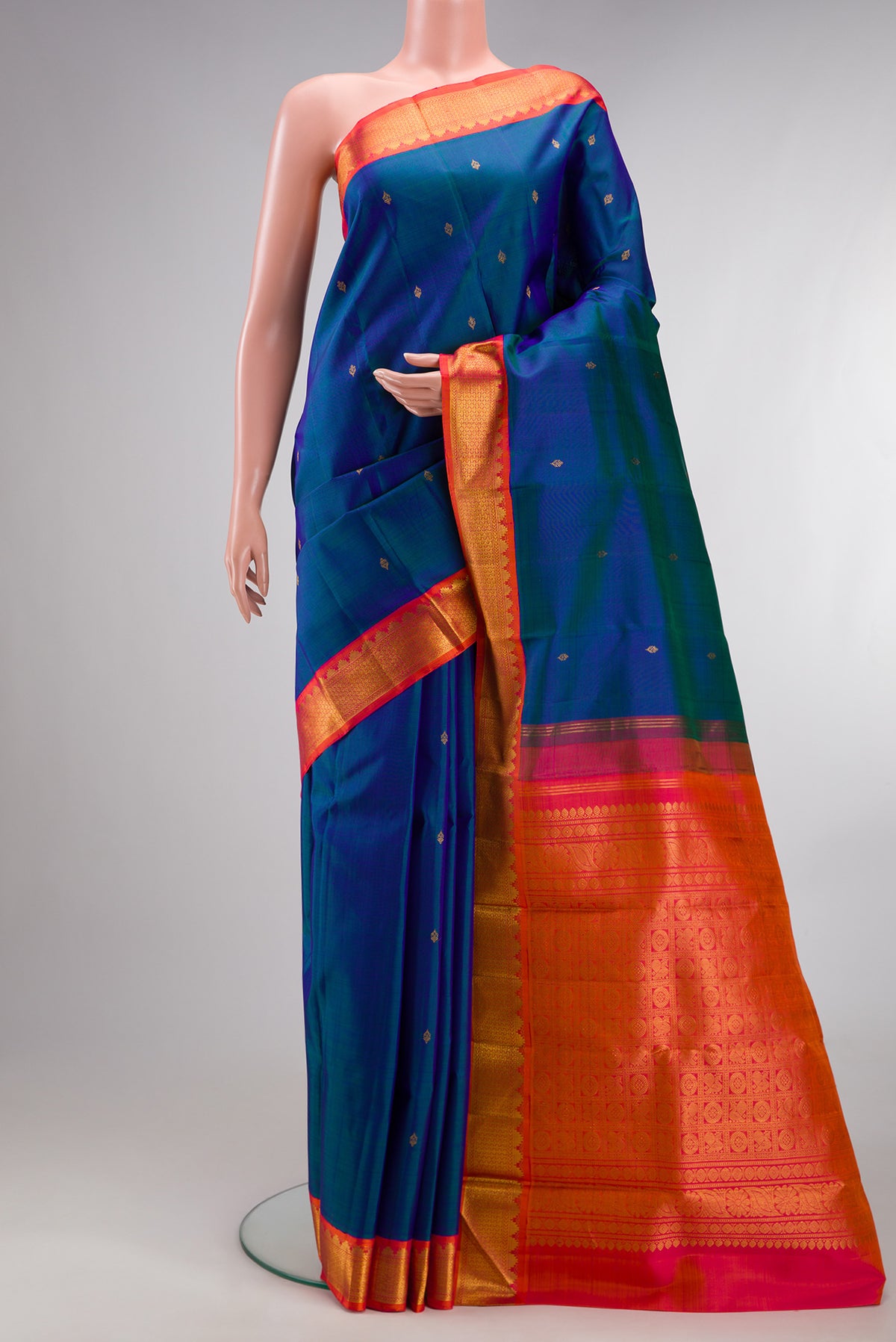 Pure Silk Peacock Blue Dual Tone Kanjivaram Saree with Zari Butta on the body and Zari Border.  displayed on a mannequin