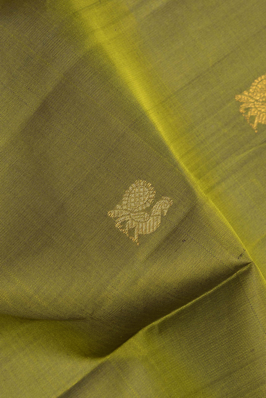 Close up of Pure Silk Mehandi Green Kanjivaram Saree with Zari Butta on the body and Zari Border.  displaying folds