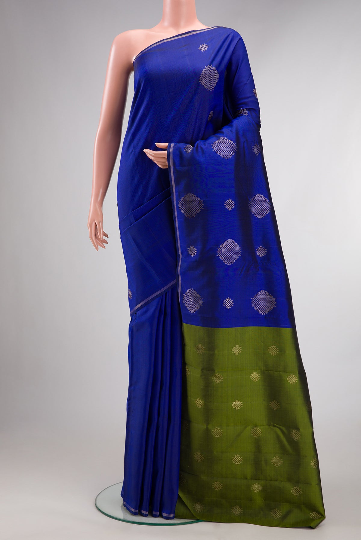 Pure Silk Royal Blue Kanchipuram Saree with Zari Butta on the body and Thin Zari Line.  displayed on a mannequin