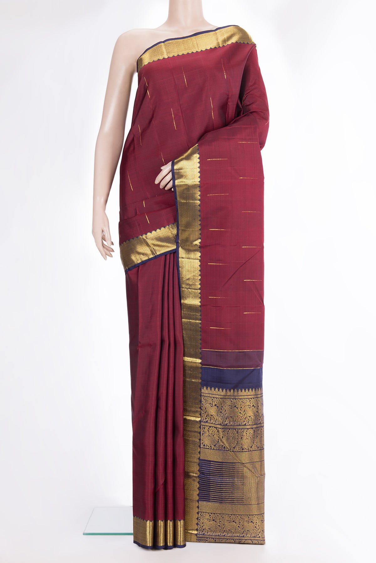 Pure Silk Maroon Kanjivaram Saree with Zari Butta on the body and Zari Border.  displayed on a mannequin