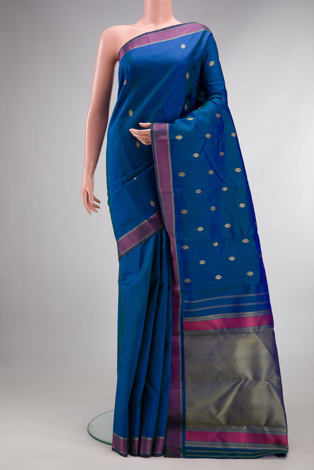 Pure Silk Peacock Blue Dual Tone Kanjivaram Saree with Thread Butta on the body and Thread Border.  displayed on a mannequin