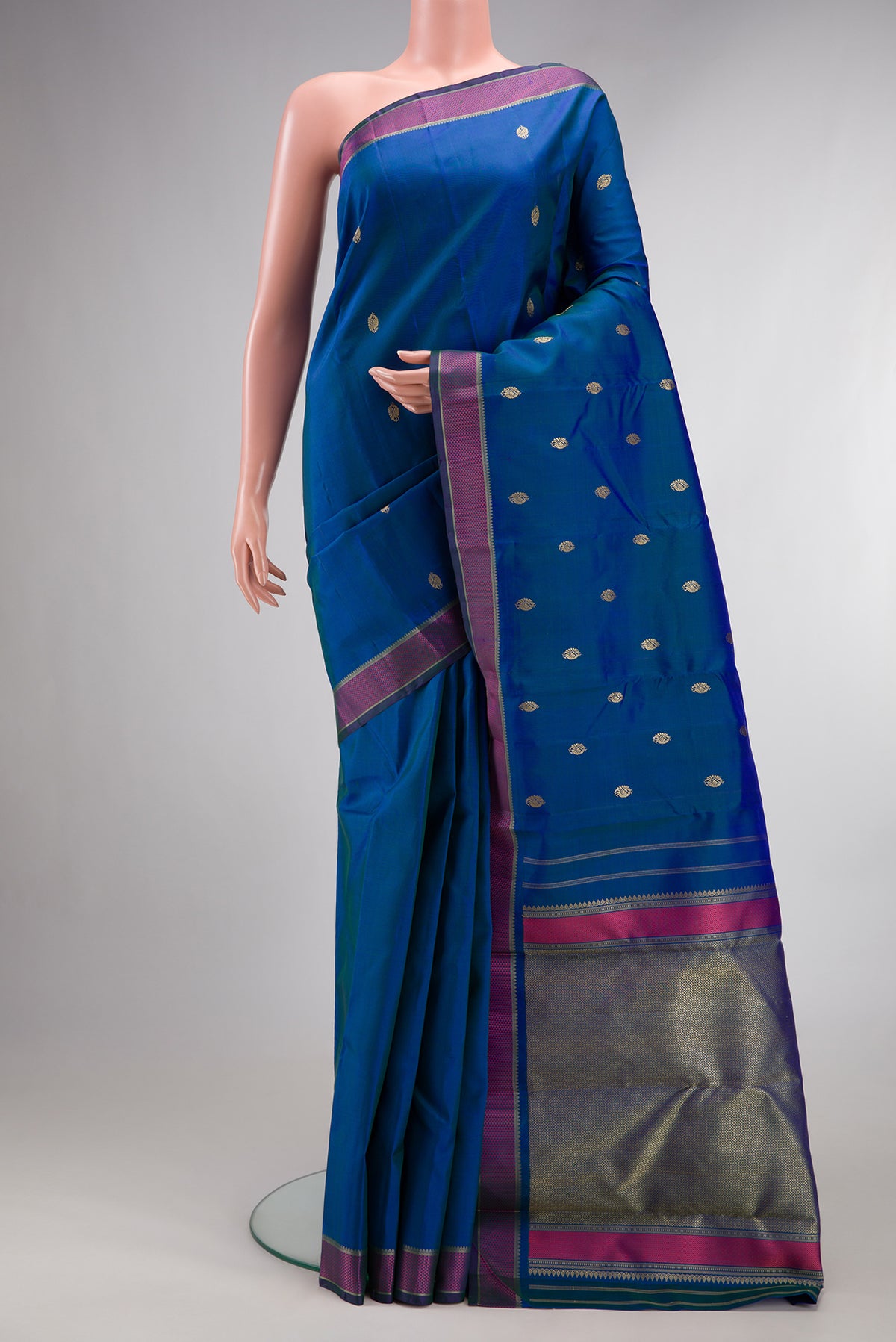 Pure Silk Peacock Blue Dual Tone Kanjivaram Saree with Thread Butta on the body and Thread Border.  displayed on a mannequin