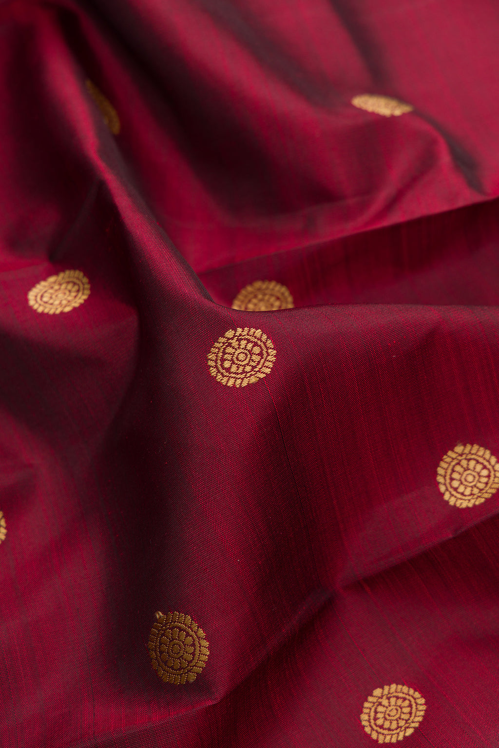 Close up of Pure Silk Maroon Kanjivaram Saree with Thread Butta on the body and Thread Border.  displaying folds