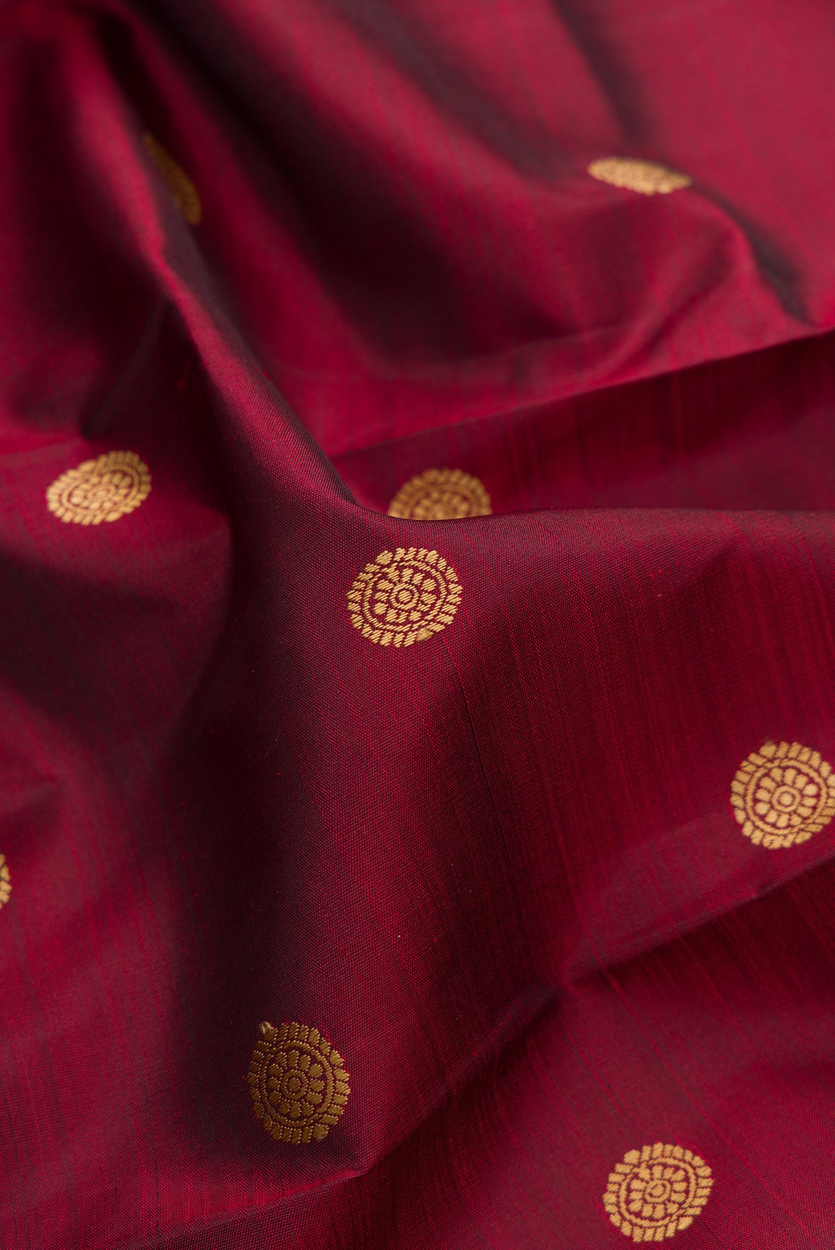 Close up of Pure Silk Maroon Kanjivaram Saree with Thread Butta on the body and Thread Border.  displaying folds