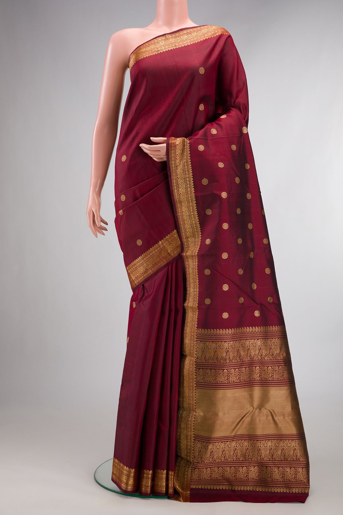 Pure Silk Maroon Kanjivaram Saree with Thread Butta on the body and Thread Border.  displayed on a mannequin
