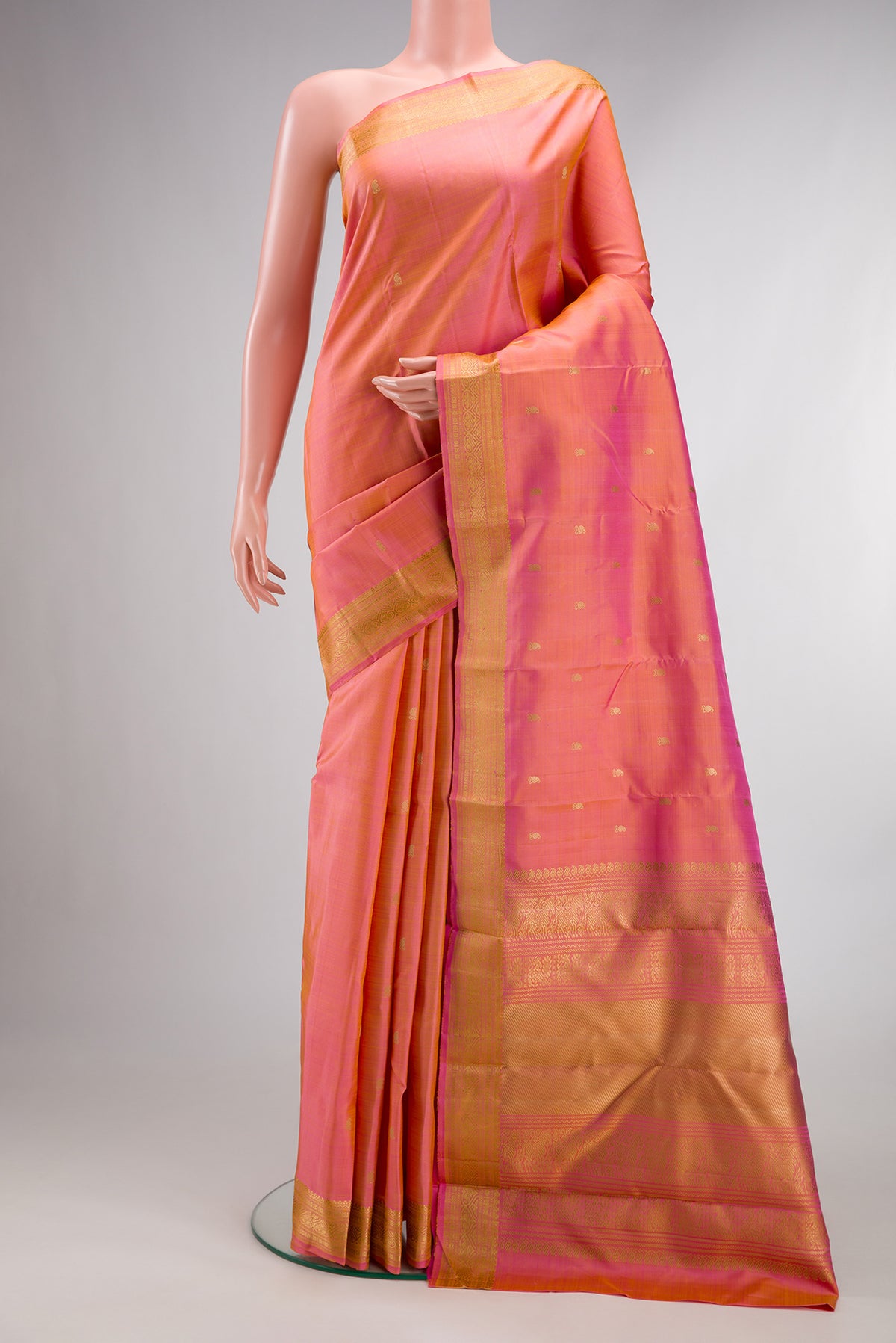 Pure Silk Pinkish Yellow Dual Tone Kanjivaram Saree with Thread Butta on the body and Thread Border.  displayed on a mannequin