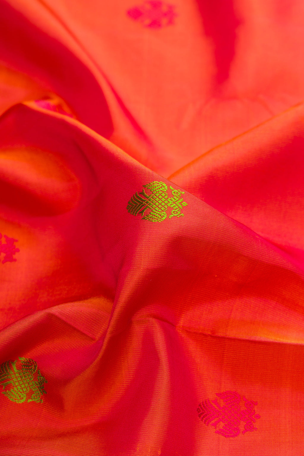 Close up of Pure Silk Orange Kanchipuram Saree with Thread Butta on the body and Thread Border.  displaying folds