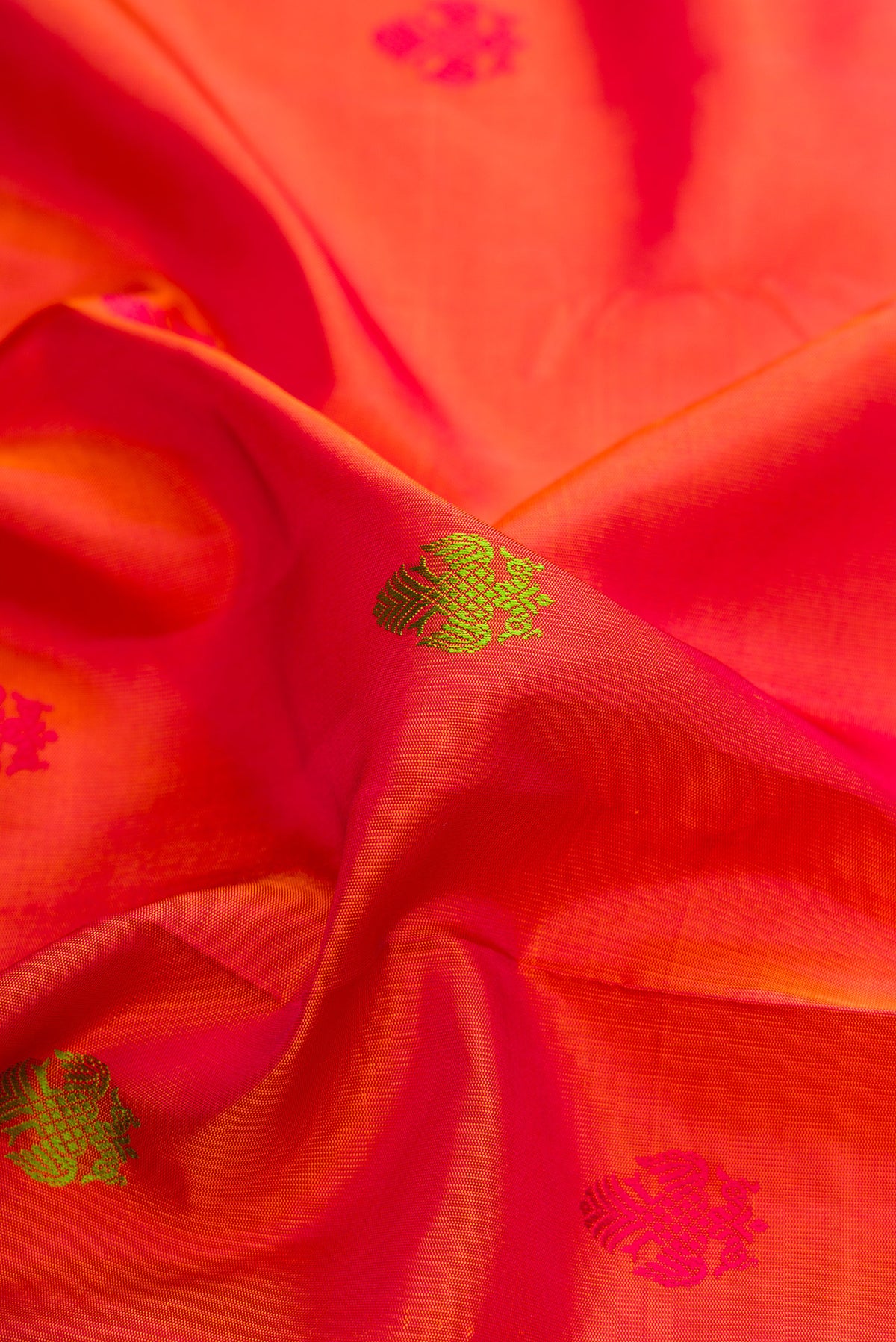 Close up of Pure Silk Orange Kanchipuram Saree with Thread Butta on the body and Thread Border.  displaying folds