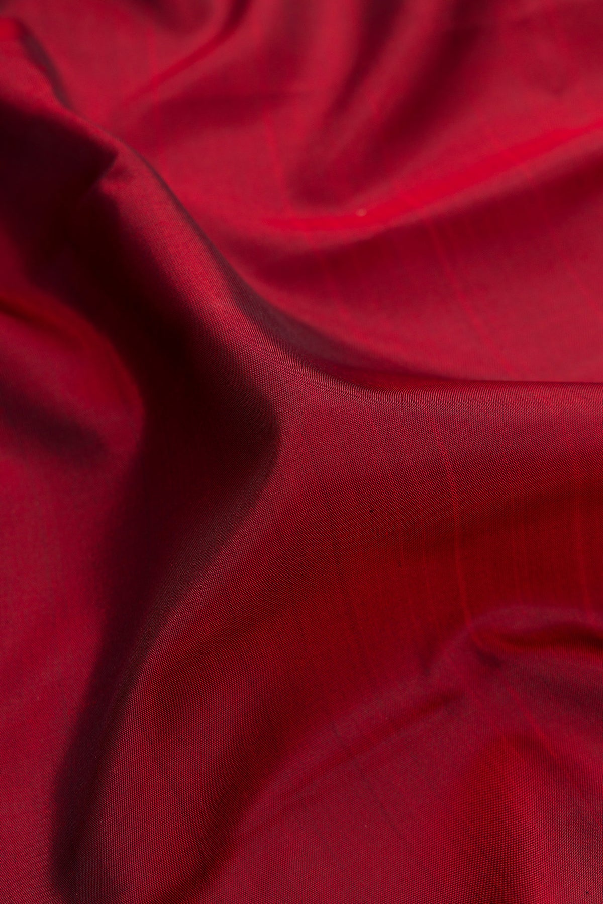 Close up of Pure Silk Maroon Kanchipuram Saree with Plain Body and Ganga Jamuna Border.  displaying folds