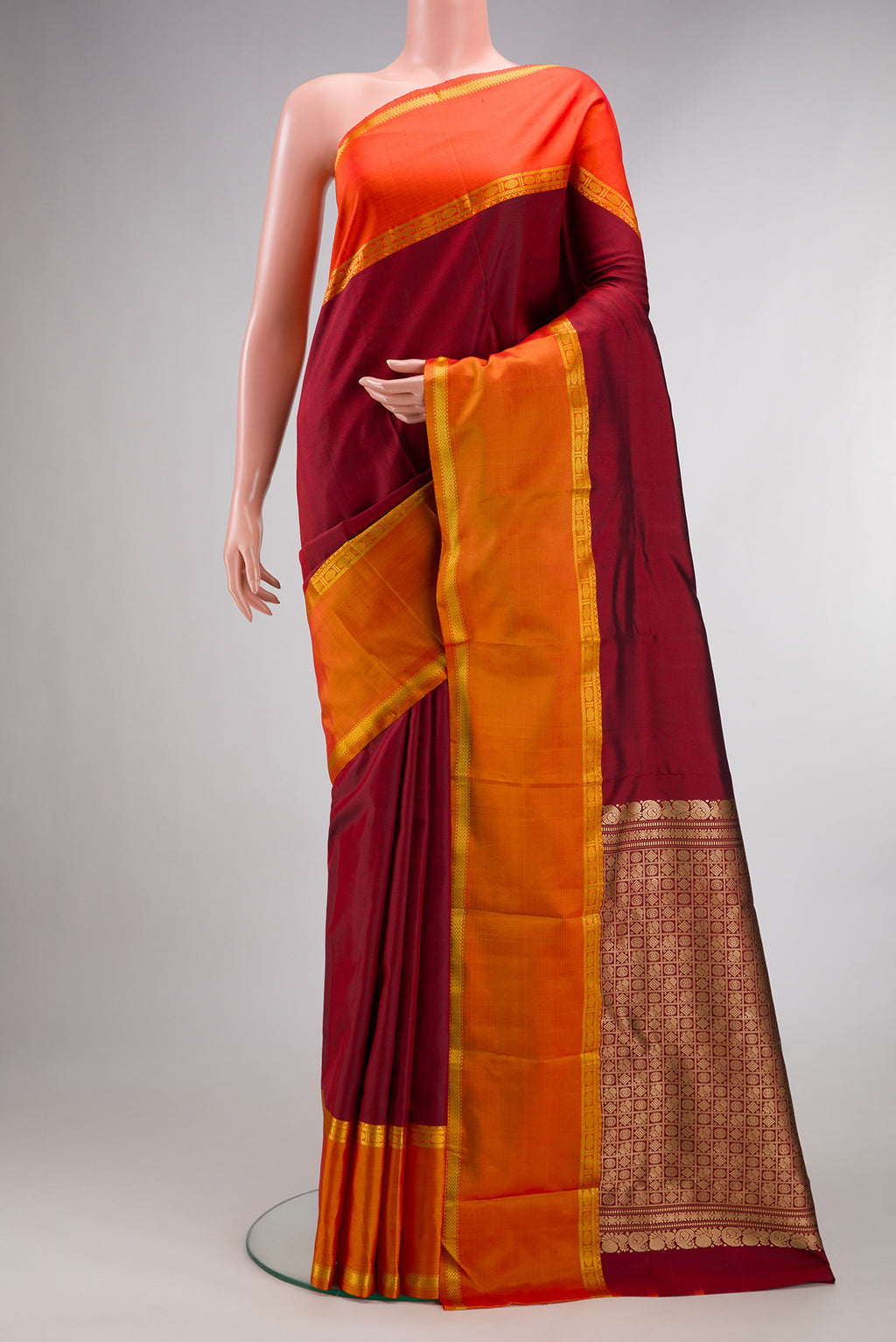 Pure Silk Maroon Kanchipuram Saree with Plain Body and Ganga Jamuna Border.  displayed on a mannequin