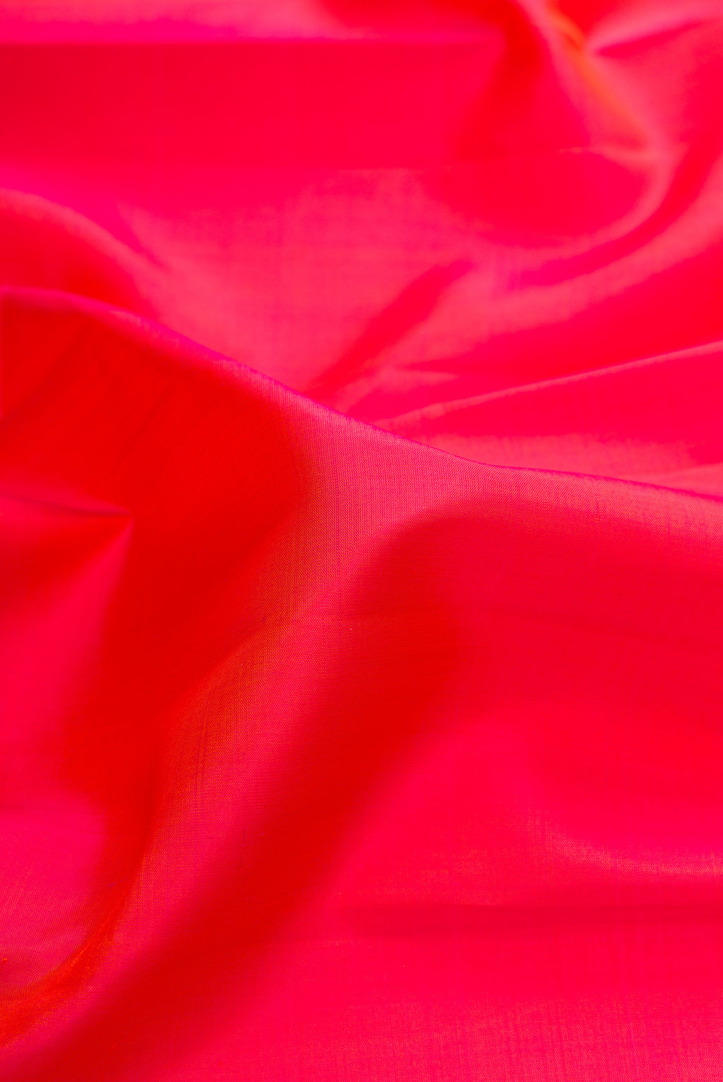 Close up of Pure Silk Brick Orange Dual Tone Kanjivaram Saree with Plain Body and Zari Border.  displaying folds